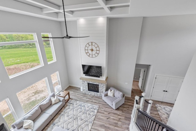 6340 Congress Dr, West Bend, WI 53095 - living room featuring wood finished floors, healthy amount of natural light, coffered ceiling, a towering ceiling, and a fireplace