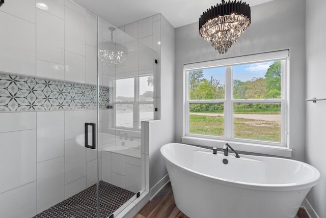 6340 Congress Dr, West Bend, WI 53095 - bathroom featuring a freestanding bath, a stall shower, a chandelier, and wood finished floors