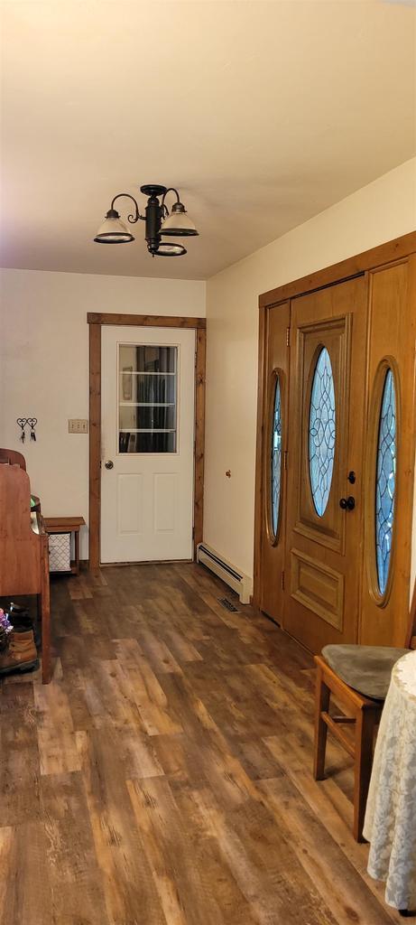 W6887 Two Mile Rd, Porterfield, WI 54159 - entrance foyer featuring a baseboard radiator and wood finished floors