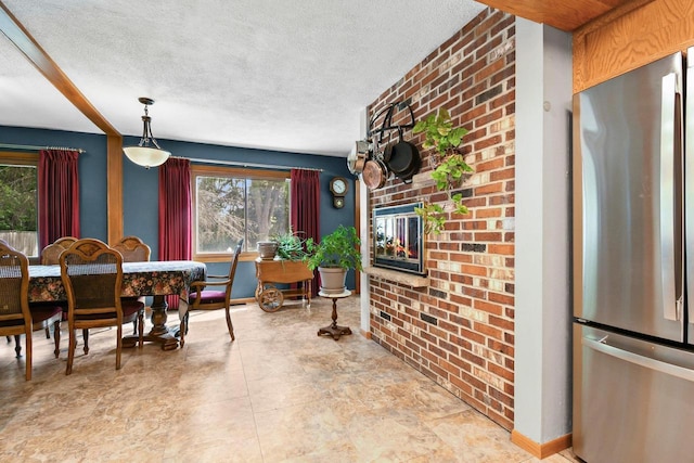 4917 Ralph Cir, Madison, WI 53714 - dining room with healthy amount of natural light, a textured ceiling, baseboards, and a glass covered fireplace
