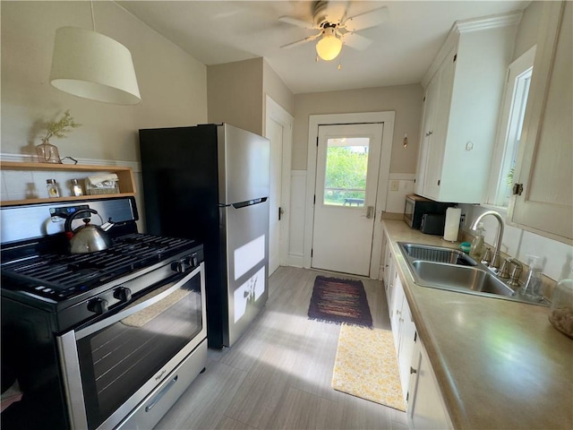 1515 Lyndale Ave, Eau Claire, WI 54701 - kitchen with stainless steel appliances, a sink, light countertops, white cabinets, and ceiling fan