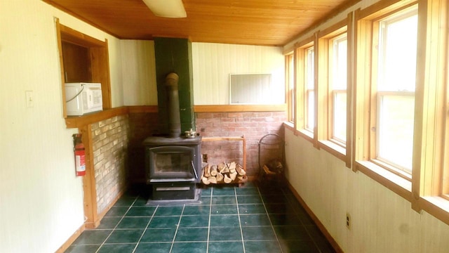 N18733 Short Cut Rd, Pembine, WI 54156 - unfurnished sunroom featuring a wood stove, wooden ceiling, tile patterned floors, and baseboards