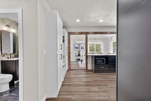 8606 State Highway 57, Baileys Harbor, WI 54202 - hallway featuring baseboards, recessed lighting, light wood-style floors, and a sink
