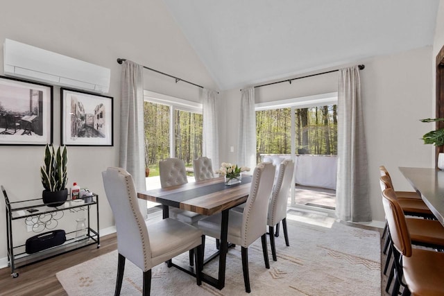 8606 State Highway 57, Baileys Harbor, WI 54202 - dining area with wood finished floors, high vaulted ceiling, a wall mounted AC, and baseboards
