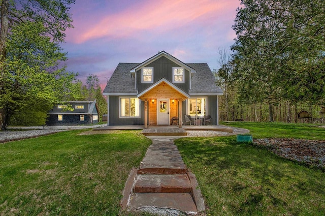 8606 State Highway 57, Baileys Harbor, WI 54202 - view of front facade featuring covered porch, a front lawn, and a shingled roof