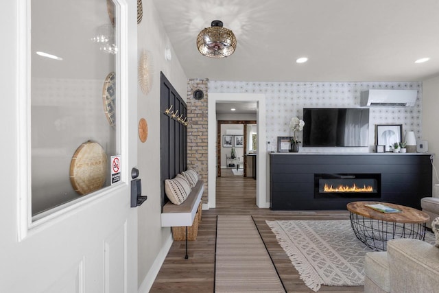 8606 State Highway 57, Baileys Harbor, WI 54202 - living room with a wall unit AC, wood finished floors, baseboards, a glass covered fireplace, and wallpapered walls