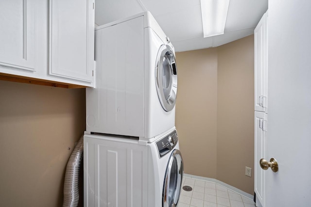 333 Lake Ave Unit 502, Racine, WI 53403 - laundry area featuring stacked washer / dryer, cabinet space, light tile patterned floors, and baseboards