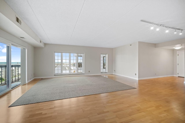 333 Lake Ave Unit 502, Racine, WI 53403 - empty room featuring rail lighting, light wood-style flooring, and healthy amount of natural light