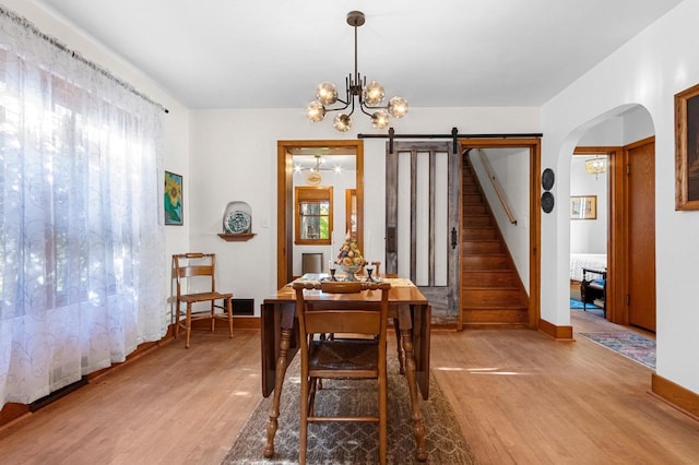 302 River Hts, Shawano, WI 54166 - dining area featuring light wood finished floors, a chandelier, arched walkways, and baseboards