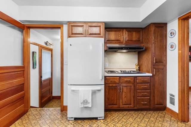 302 River Hts, Shawano, WI 54166 - kitchen featuring freestanding refrigerator, under cabinet range hood, gas cooktop, and brown cabinetry
