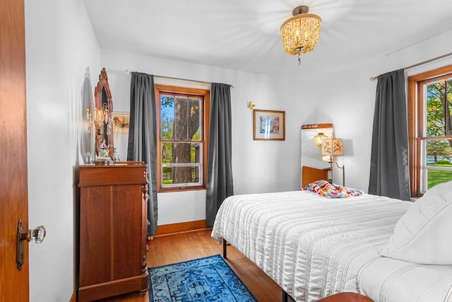302 River Hts, Shawano, WI 54166 - bedroom featuring wood finished floors, baseboards, and a chandelier