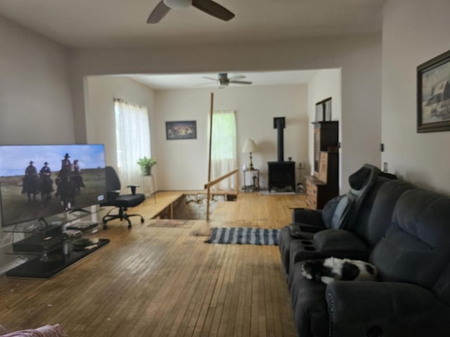 201 Center St, Elroy, WI 53929 - living area with a ceiling fan, a wood stove, healthy amount of natural light, and hardwood / wood-style floors