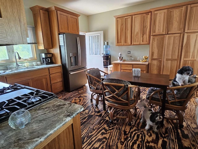 201 Center St, Elroy, WI 53929 - kitchen featuring stainless steel fridge, a sink, brown cabinetry, and light stone counters
