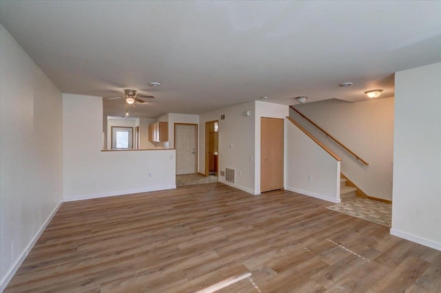 252 S Musket Ridge Dr Unit 2, Sun Prairie, WI 53590 - unfurnished living room with light wood finished floors, stairs, a ceiling fan, and baseboards