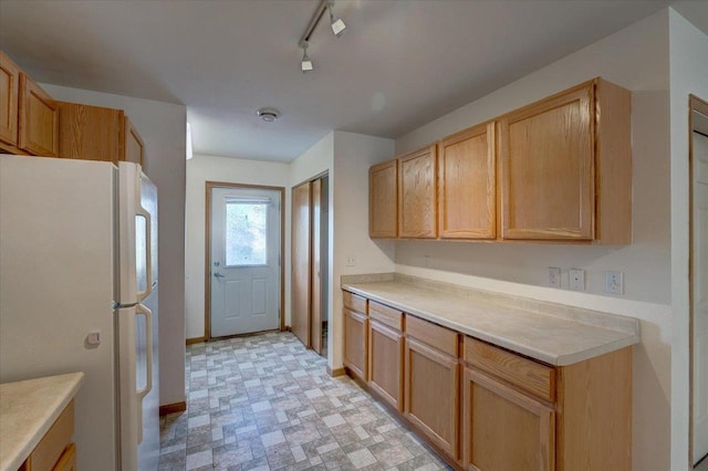 252 S Musket Ridge Dr Unit 2, Sun Prairie, WI 53590 - kitchen featuring freestanding refrigerator, light countertops, light flooring, baseboards, and rail lighting