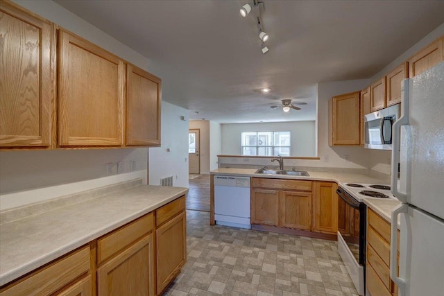 252 S Musket Ridge Dr Unit 2, Sun Prairie, WI 53590 - kitchen with white appliances, a sink, light countertops, a ceiling fan, and a peninsula