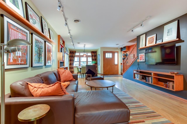 127 S Franklin St Unit 10, Madison, WI 53703 - living room featuring track lighting, wood finished floors, stairs, and baseboards