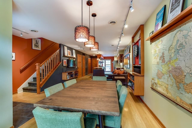 127 S Franklin St Unit 10, Madison, WI 53703 - dining room with rail lighting, light wood-style flooring, stairs, and baseboards