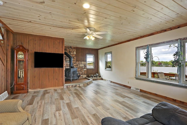 10317 195th Ave, Bristol, WI 53104 - living room featuring a wood stove, wood ceiling, wooden walls, baseboards, and light wood-style flooring