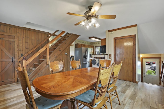 10317 195th Ave, Bristol, WI 53104 - dining room featuring stairs, light wood-type flooring, a ceiling fan, washer / dryer, and wooden walls