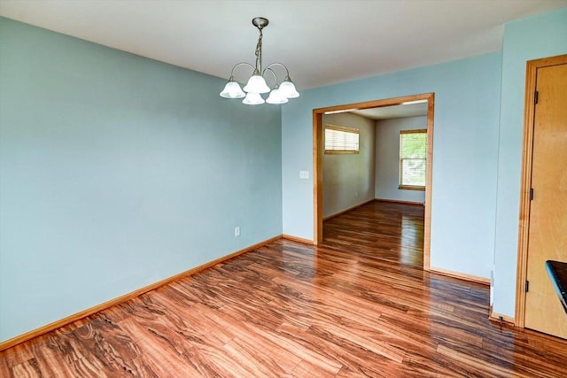 9305 Briar Haven Dr, Verona, WI 53593 - empty room featuring wood finished floors, a chandelier, and baseboards