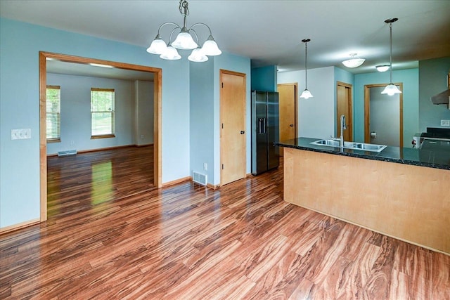 9305 Briar Haven Dr, Verona, WI 53593 - kitchen with black refrigerator with ice dispenser, a sink, wood finished floors, and electric range