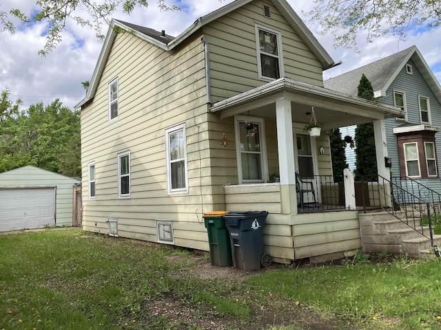 397 W Division St, Fond Du Lac, WI 54935 - view of property exterior with covered porch, an outdoor structure, a detached garage, and a lawn