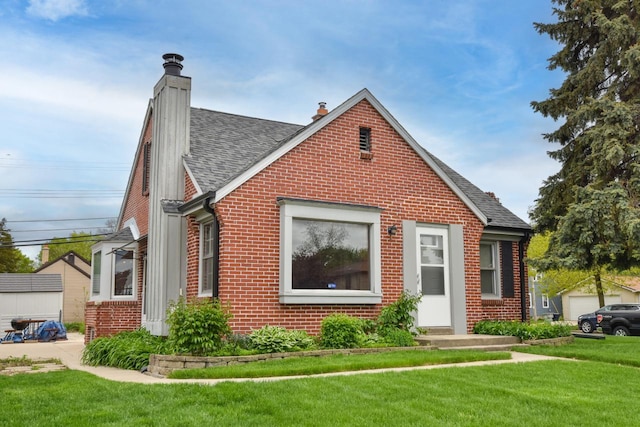 10339 W Hampton Ave, Milwaukee, WI 53225 - view of front of house featuring brick siding, a shingled roof, a front yard, and a chimney