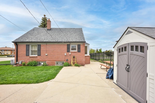 10339 W Hampton Ave, Milwaukee, WI 53225 - view of property exterior with a chimney, roof with shingles, a patio, and brick siding