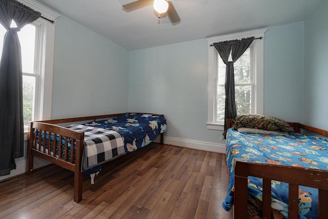 375 S Bridge St, Markesan, WI 53946 - bedroom featuring wood finished floors, multiple windows, baseboards, and ceiling fan