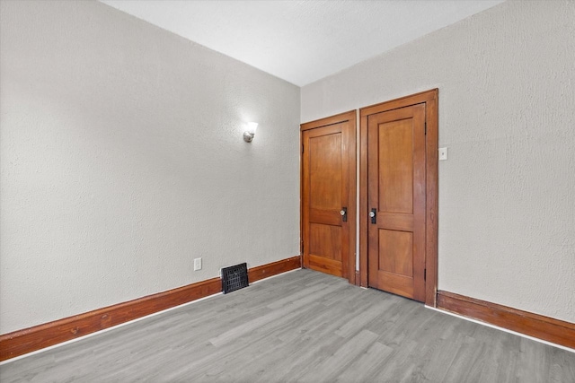 3046 N 57th St, Milwaukee, WI 53210 - unfurnished room featuring light wood finished floors, baseboards, and a textured wall