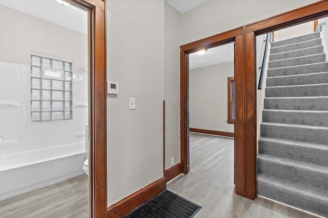 3046 N 57th St, Milwaukee, WI 53210 - staircase featuring wood finished floors, a textured wall, and baseboards