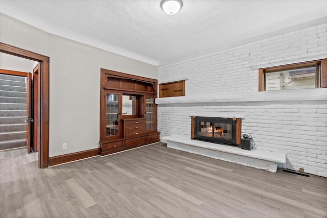3046 N 57th St, Milwaukee, WI 53210 - unfurnished living room featuring wood finished floors, a fireplace, and baseboards