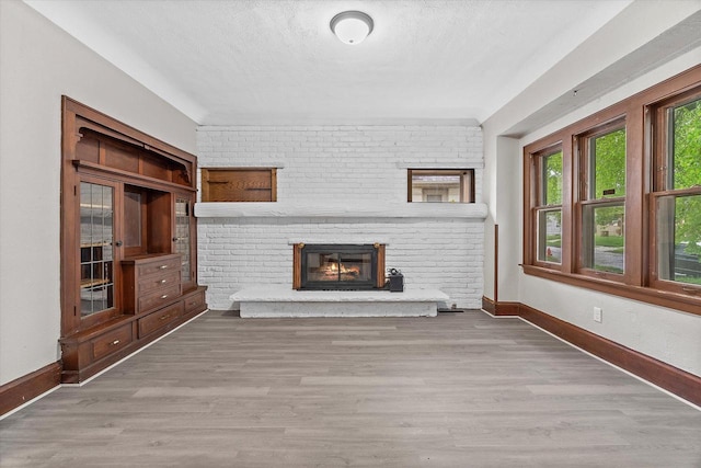 3046 N 57th St, Milwaukee, WI 53210 - unfurnished living room featuring baseboards, wood finished floors, a fireplace, and a textured ceiling