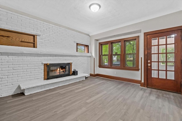 3046 N 57th St, Milwaukee, WI 53210 - unfurnished living room featuring baseboards, wood finished floors, and a fireplace