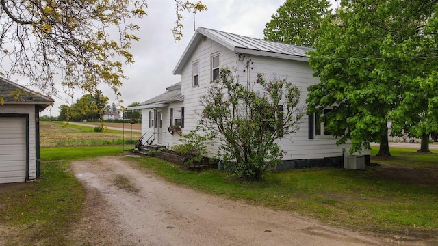 E3722 County Road Ee, Waupaca, WI 54981 - view of front of house with metal roof, driveway, cooling unit, and a front yard