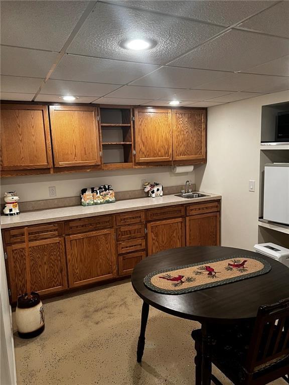 10384 W County Line Rd, Exeland, WI 54835 - kitchen with a sink, brown cabinetry, a drop ceiling, light countertops, and open shelves
