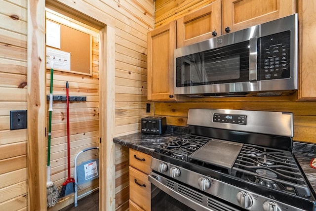 N11594 Woodland Dr, Tomahawk, WI 54487 - kitchen with appliances with stainless steel finishes, wooden walls, dark countertops, and brown cabinets