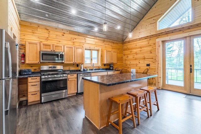 N11594 Woodland Dr, Tomahawk, WI 54487 - kitchen with appliances with stainless steel finishes, wooden walls, a breakfast bar, dark countertops, and wooden ceiling