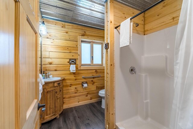 N11594 Woodland Dr, Tomahawk, WI 54487 - full bathroom featuring a stall shower, toilet, vanity, wood finished floors, and wooden walls