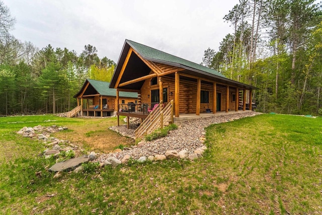 N11594 Woodland Dr, Tomahawk, WI 54487 - view of front of home featuring log exterior, a front lawn, and a forest view