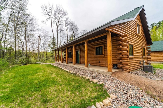 N11594 Woodland Dr, Tomahawk, WI 54487 - view of property exterior with log exterior, a yard, central air condition unit, and a shingled roof