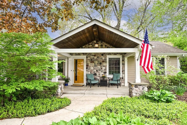 1333 N 120th St, Wauwatosa, WI 53226 - property entrance featuring covered porch, stone siding, and a shingled roof