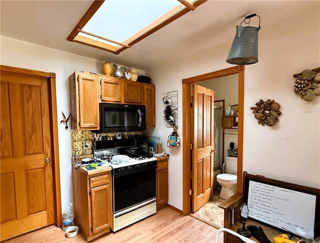 10302W Cty Rd, D, Exeland, WI 54835 - kitchen featuring black microwave, gas stove, decorative backsplash, light wood finished floors, and light countertops