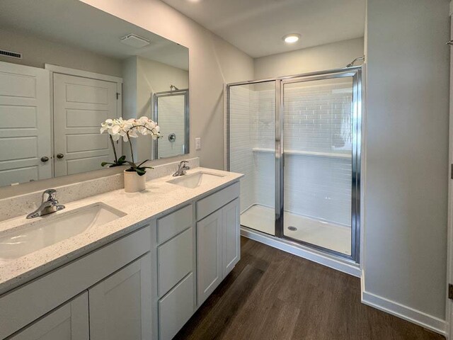 505 Oak Opening Dr, Stoughton, WI 53589 - full bathroom featuring wood finished floors, double vanity, and a shower stall