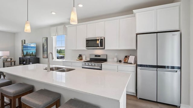 505 Oak Opening Dr, Stoughton, WI 53589 - kitchen with stainless steel appliances, white cabinetry, a kitchen island with sink, recessed lighting, and wood finished floors