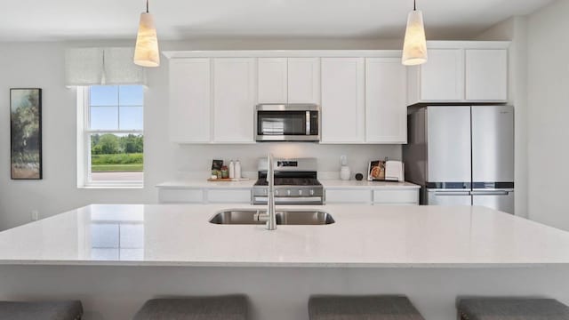 505 Oak Opening Dr, Stoughton, WI 53589 - kitchen featuring appliances with stainless steel finishes, white cabinetry, decorative light fixtures, and a breakfast bar