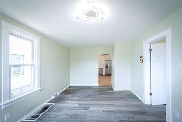 3834 Sheridan Rd, Kenosha, WI 53140 - spare room with arched walkways, dark wood-style floors, and baseboards