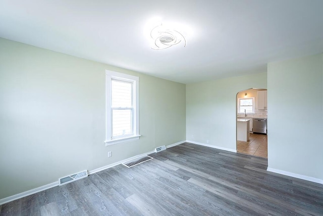 3834 Sheridan Rd, Kenosha, WI 53140 - empty room with arched walkways, plenty of natural light, and dark wood-style floors
