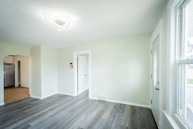 3834 Sheridan Rd, Kenosha, WI 53140 - unfurnished room featuring arched walkways, wood finished floors, and baseboards